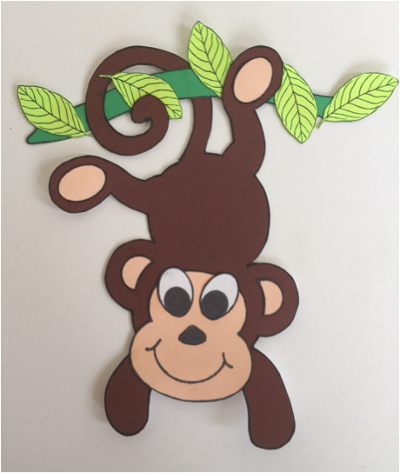 monkey hanging from branch with leaves